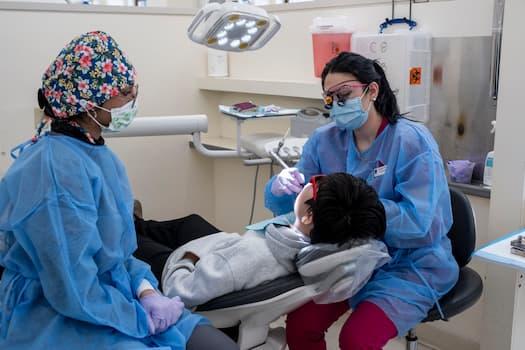 Amanda Collison examining the mouth of a peds patient.