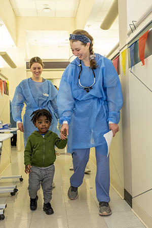 child holding hand of dental student going to appointment