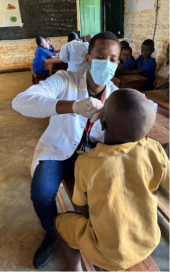 a Rwandan medical student conducts an oral screening