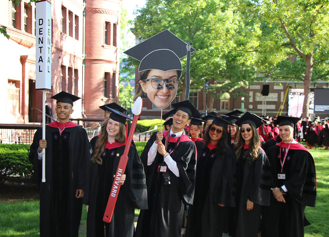 Grads march into Harvard Yard in caps and gowns