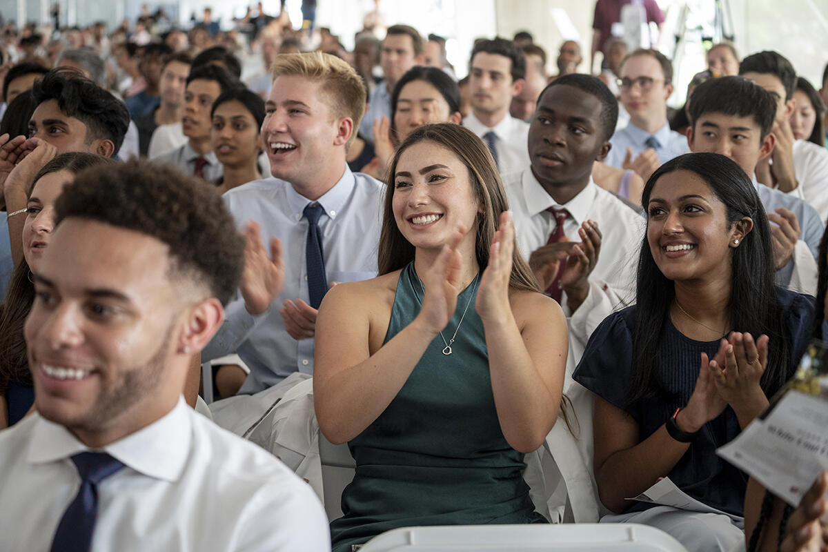students clapping at white coat ceremony