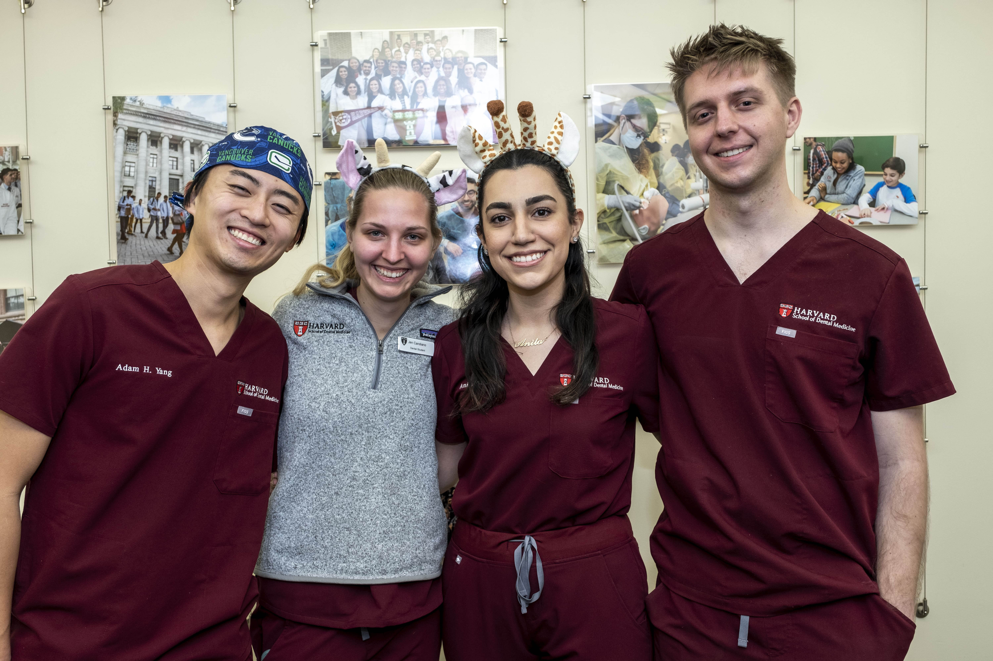 Four students standing together wearing crimson scrubs
