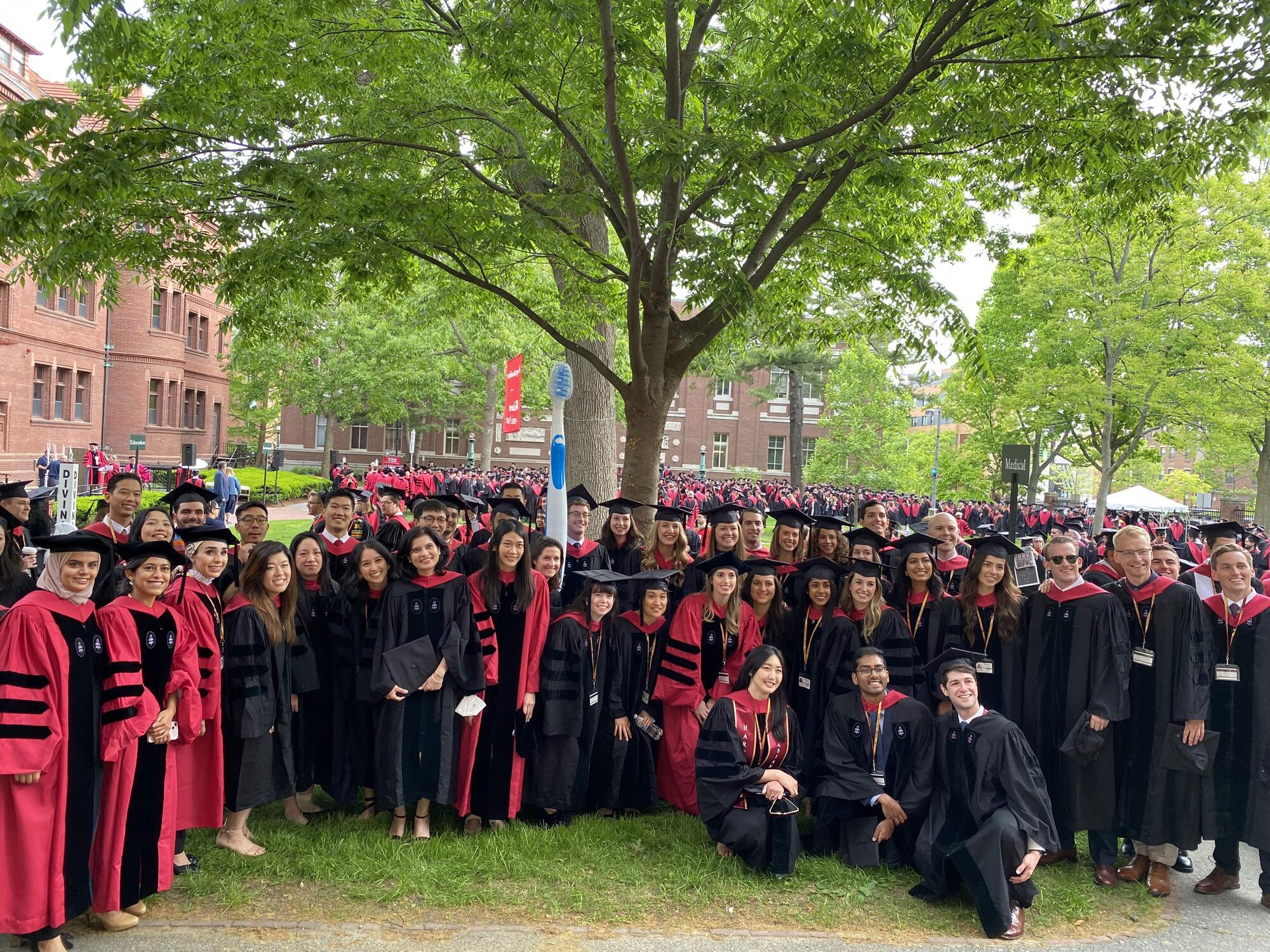 Group of students standing together outside wearing regalia