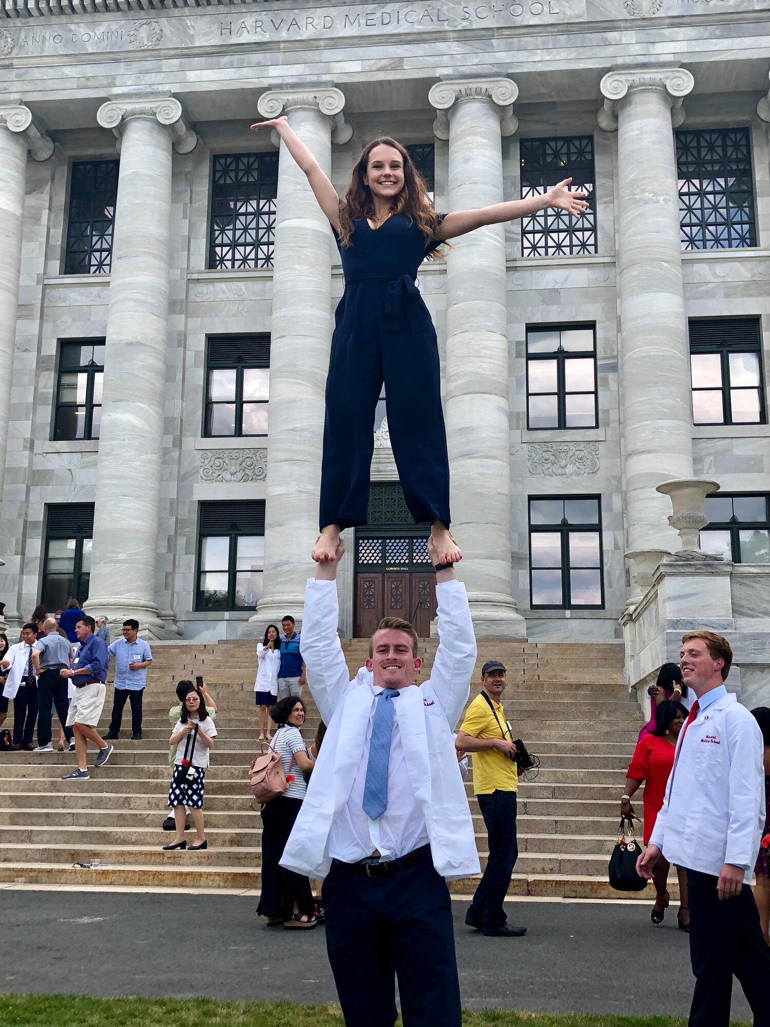 One person holding other person above their head, cheerleading