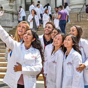 students in white coats taking selfie