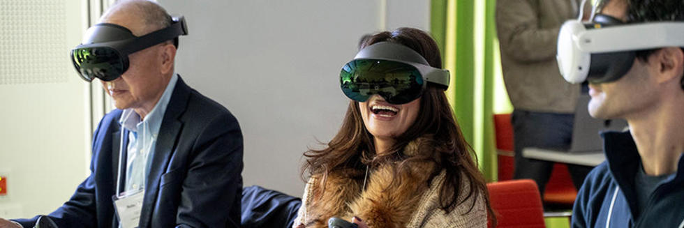 Three AI symposium participants wearing virtual reality headsets.