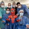 Group of dentists with young patient dressed as Spiderman