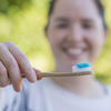 Photo of a woman with a bamboo toothbrush